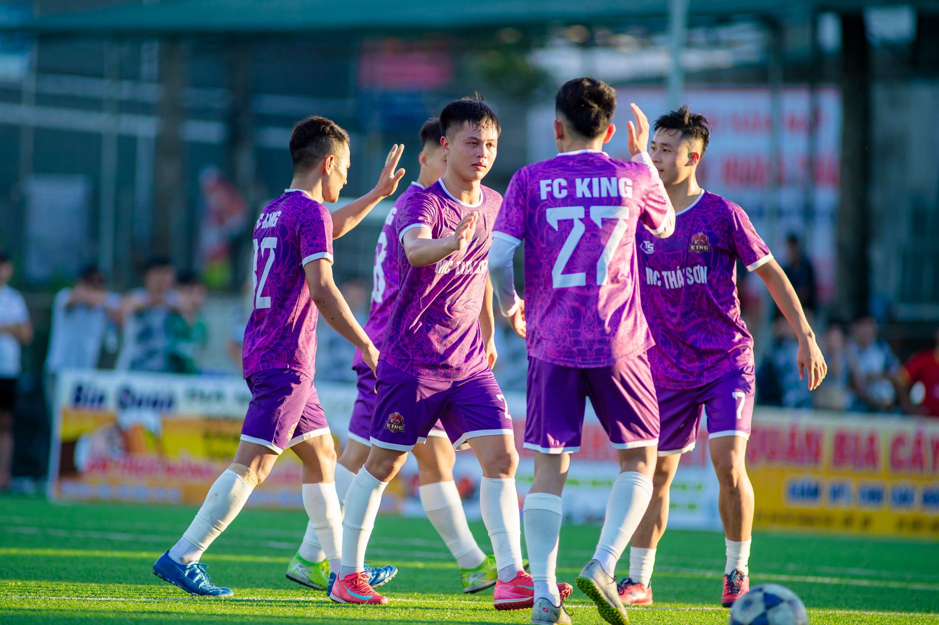 Tim pemain muda merayakan gol di lapangan sepak bola luar ruangan di Hanoi, Vietnam.