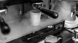 Sebuah foto close-up hitam-putih dari pembuatan espresso di kafe Budapest.