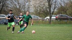 Foto aksi dari pertandingan sepak bola amatir di taman, menampilkan kerja sama tim dan keterampilan.
