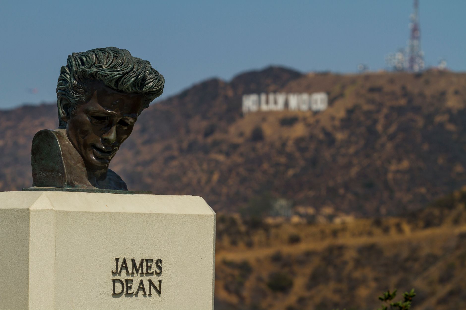 Patung dada James Dean dengan tanda ikonik Hollywood di latar belakang, Los Angeles